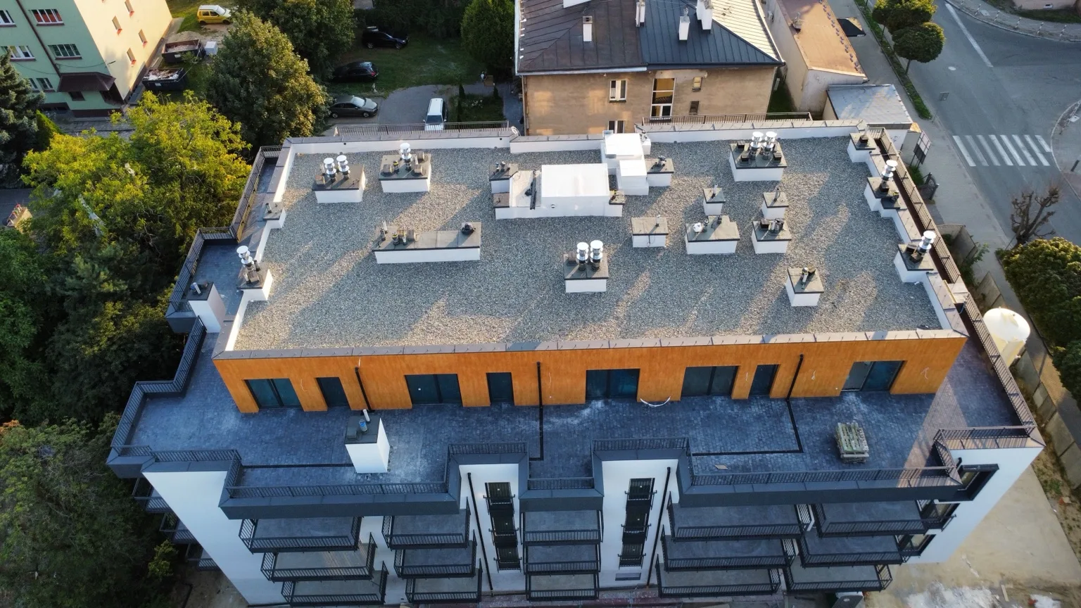 Dach płaski budynku mieszkalnego z balkonami, pokrycie żwirowe, ujęcie z drona