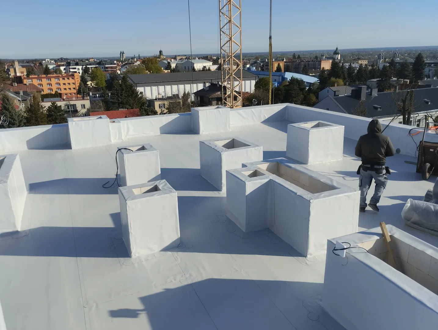 Dekarz Roofing K.B. przy pracy na dachu płaskim
