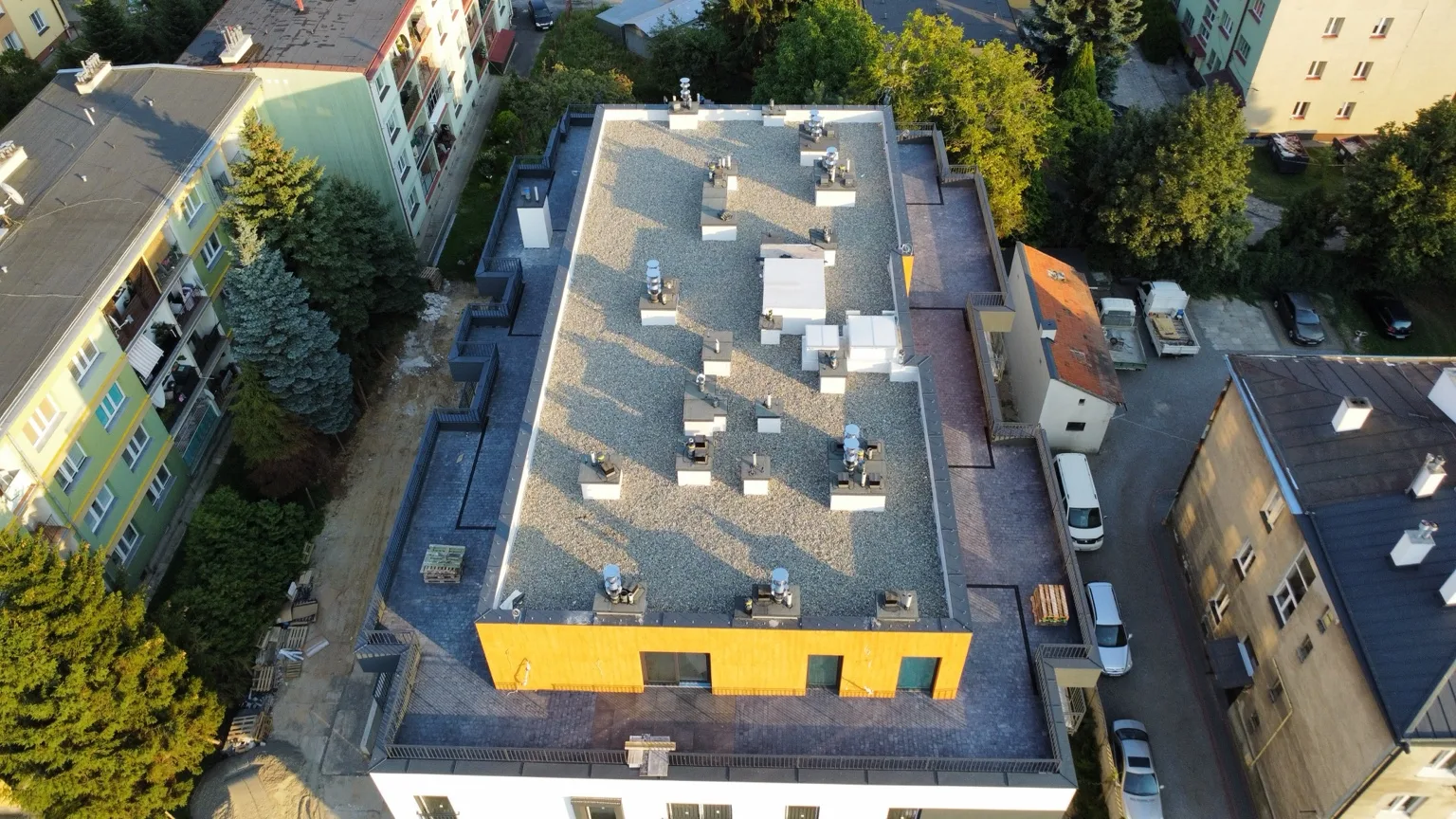 Budynek wielorodzinny w budowie z niemal ukończonym dachem balastowym